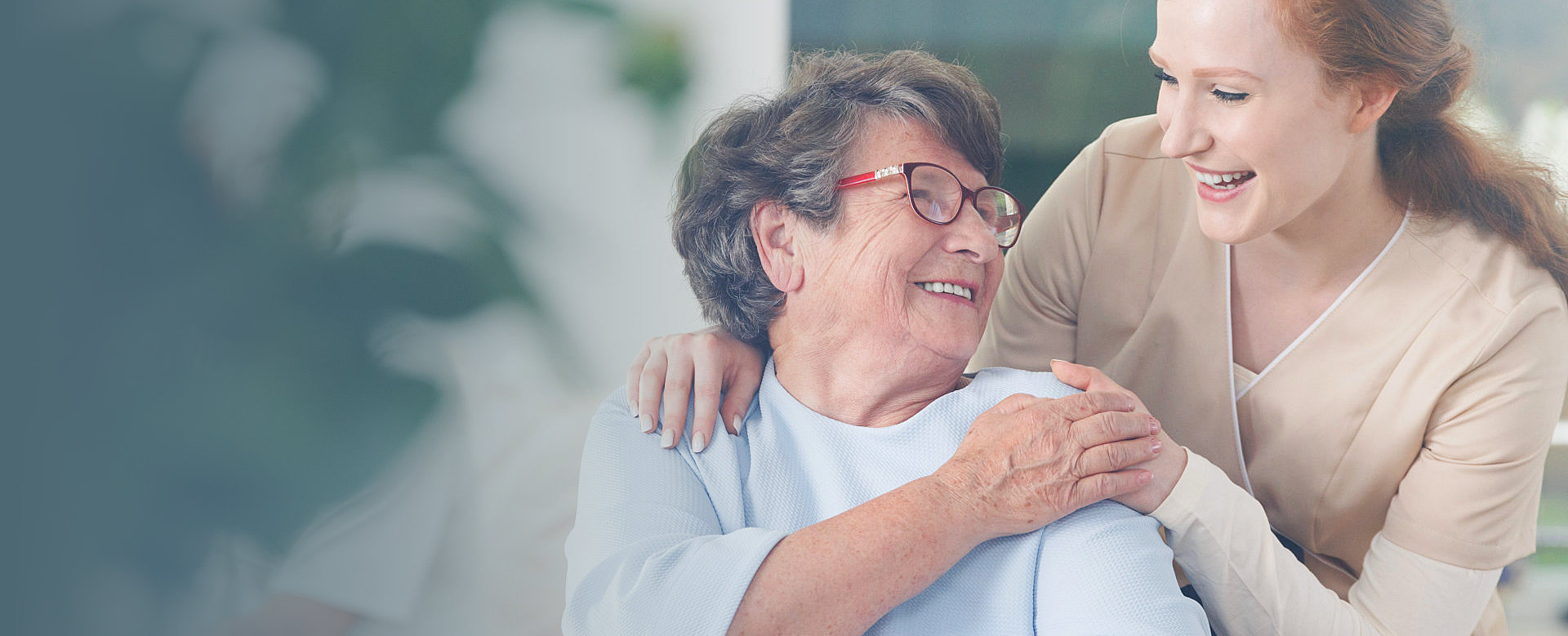 caregiver and elderly woman smiling