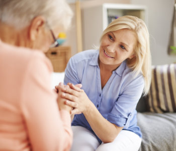 caregiver holding the hands of elderly woman